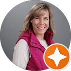 Smiling blonde woman wearing a pink vest, circular portrait with an orange star icon.